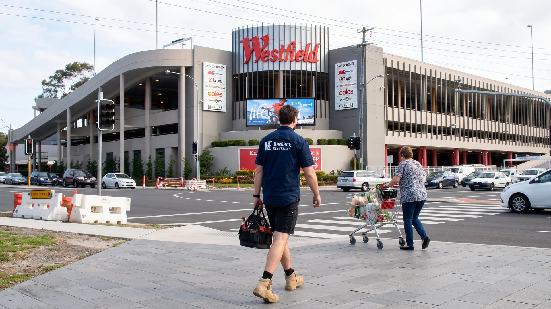 A Barrack Electrical electrician crossing the forecourt at Westfield Kotara with his tool bag
