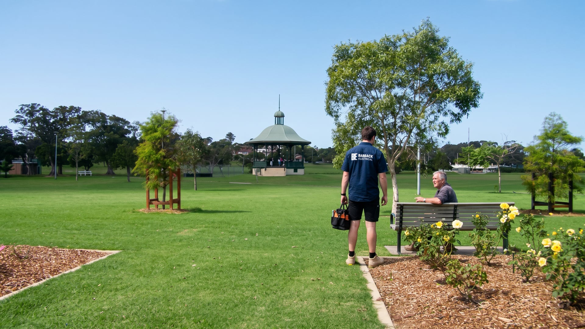 A Barrack Electrical electrician crossing Lambton Park with his tool bag