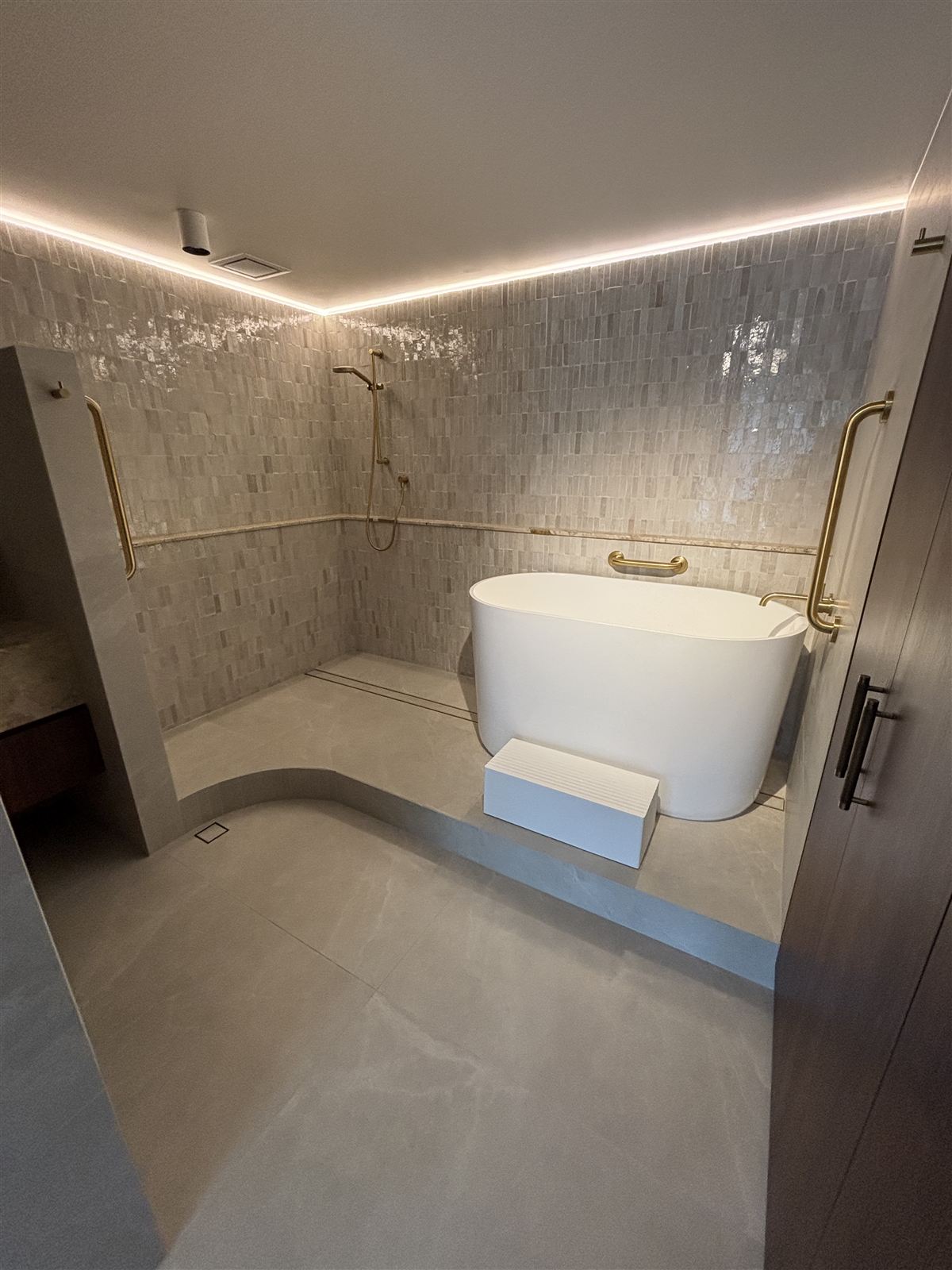 Bathroom ceiling with an exhaust fan vent and LED cove lighting above a freestanding bath