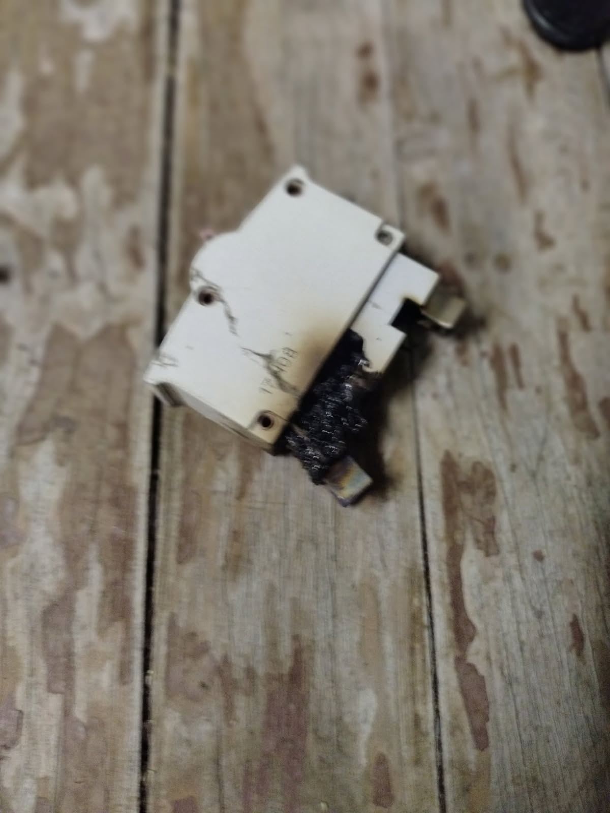 Burnt and melted circuit breaker removed from a switchboard during an electrical repair