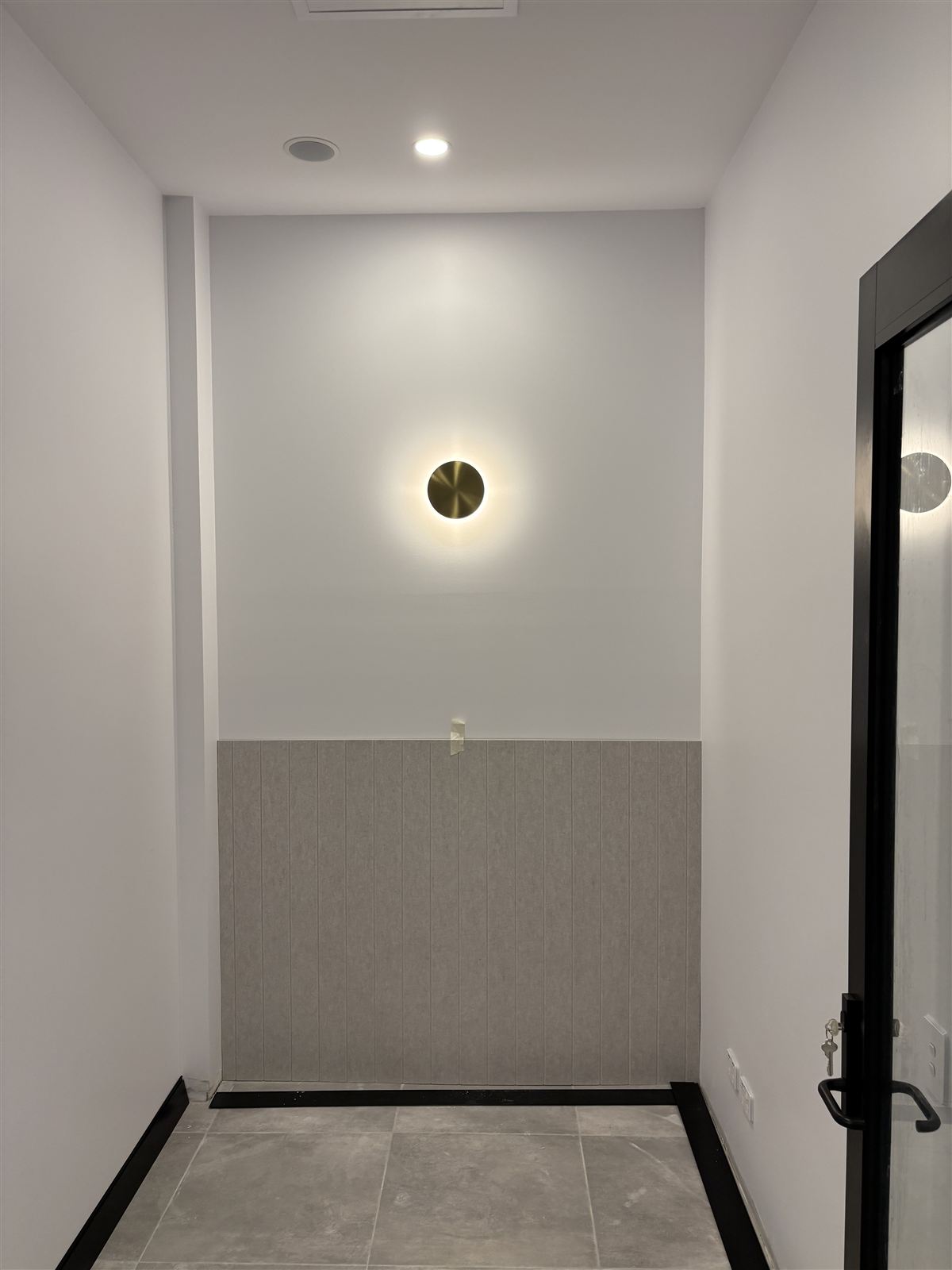A wall light in the corridor of a finished commercial fit-out