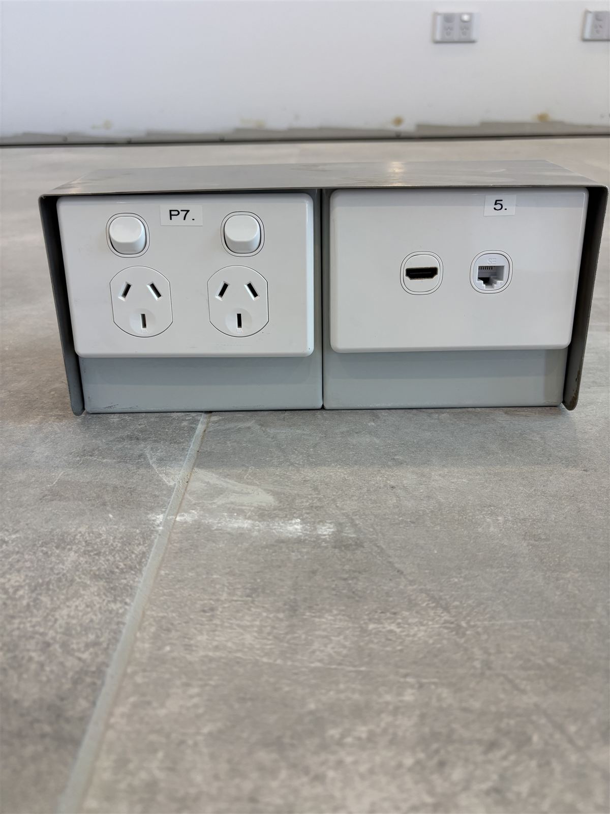 Floor box with a labelled double power point beside HDMI and data outlets