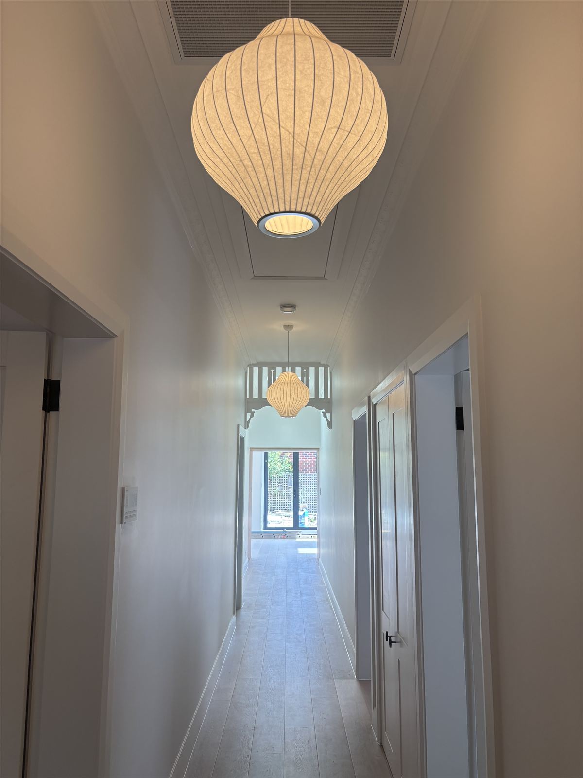 Paper pendant lights down a hallway ceiling