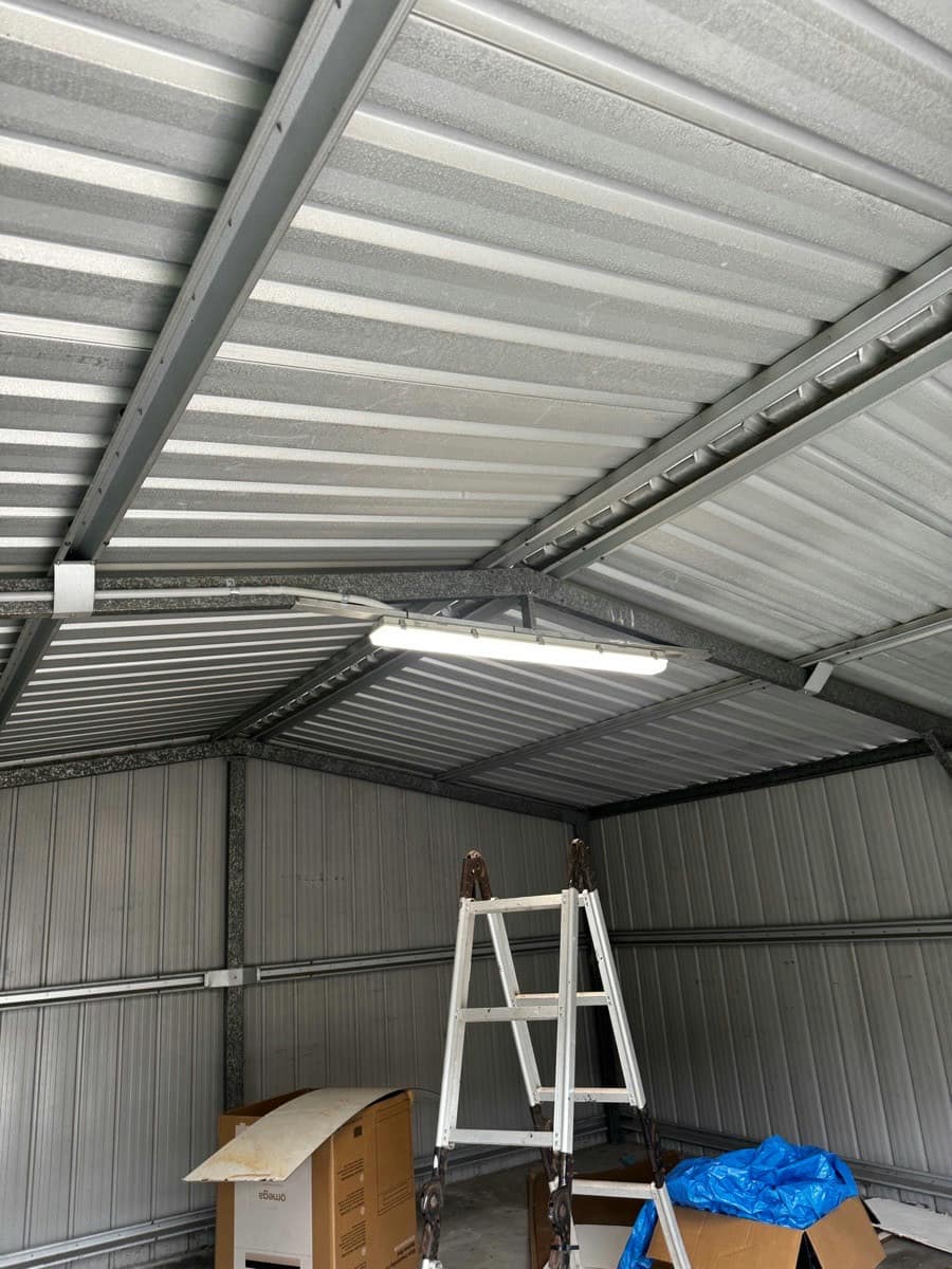 A large colorbond shed with a new LED batten lit on the roof structure