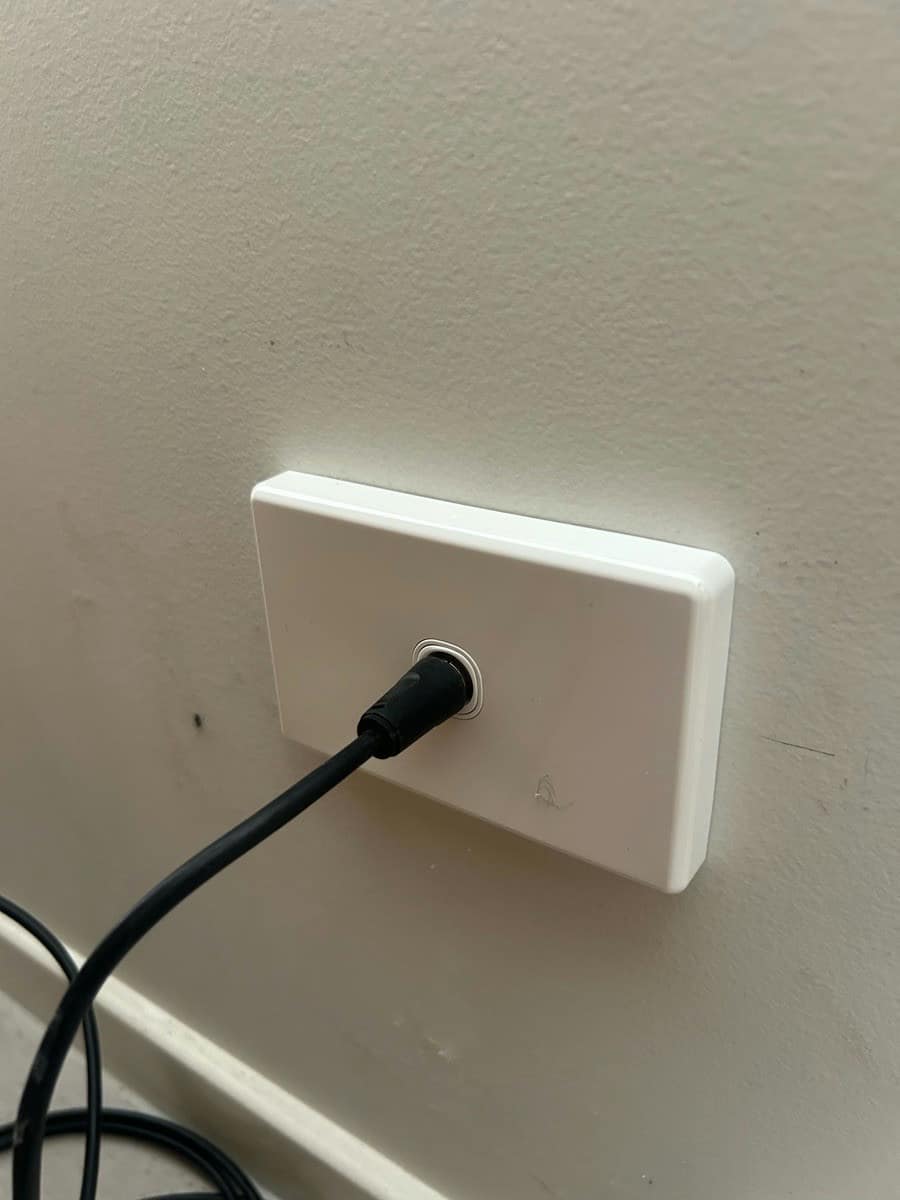 A television outlet with a coaxial lead plugged in