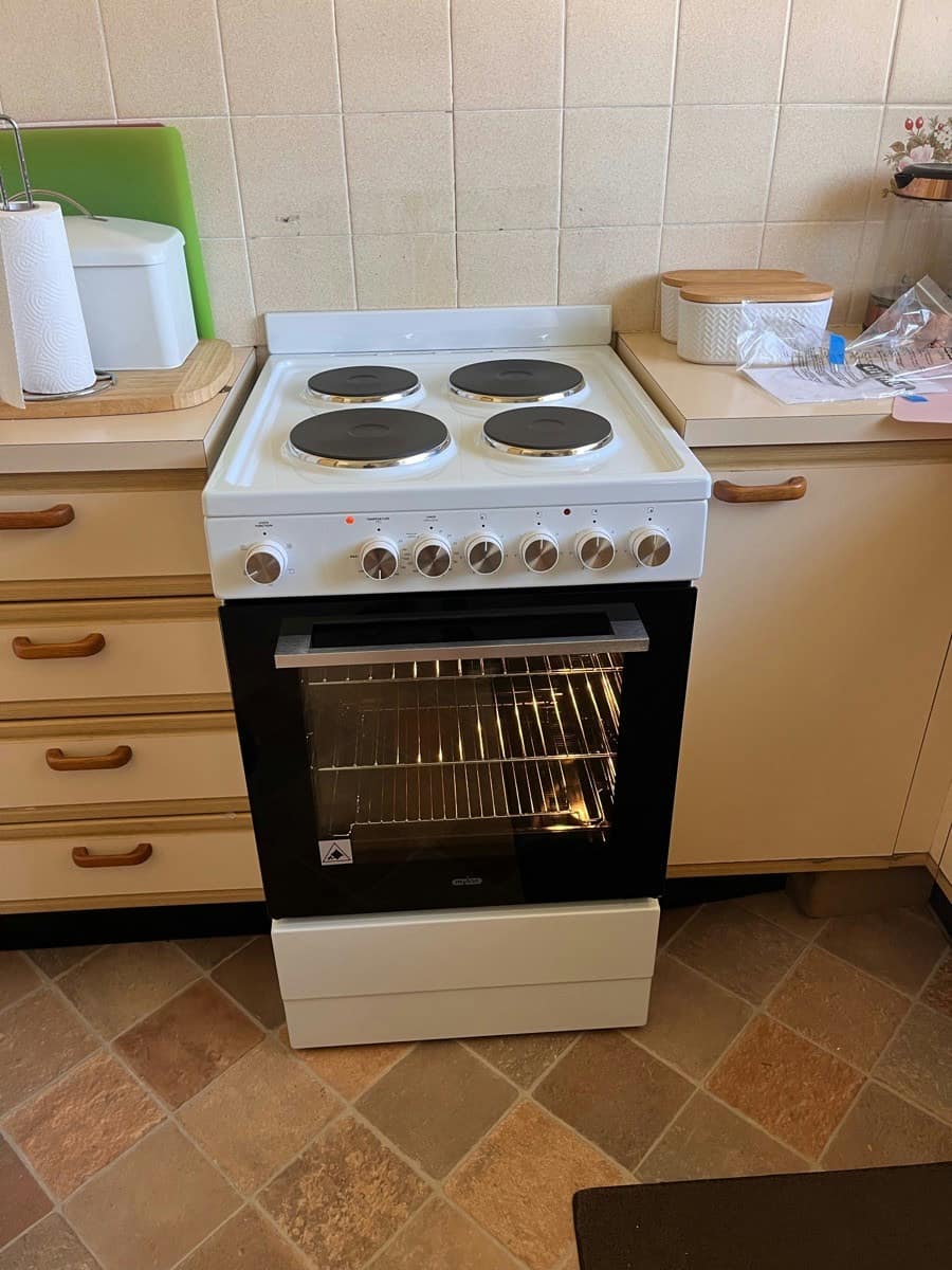 A new freestanding stove installed with the oven door open and the light on