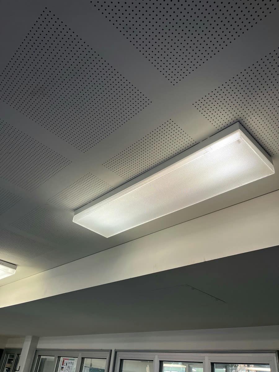 A new recessed LED panel lit in a perforated ceiling