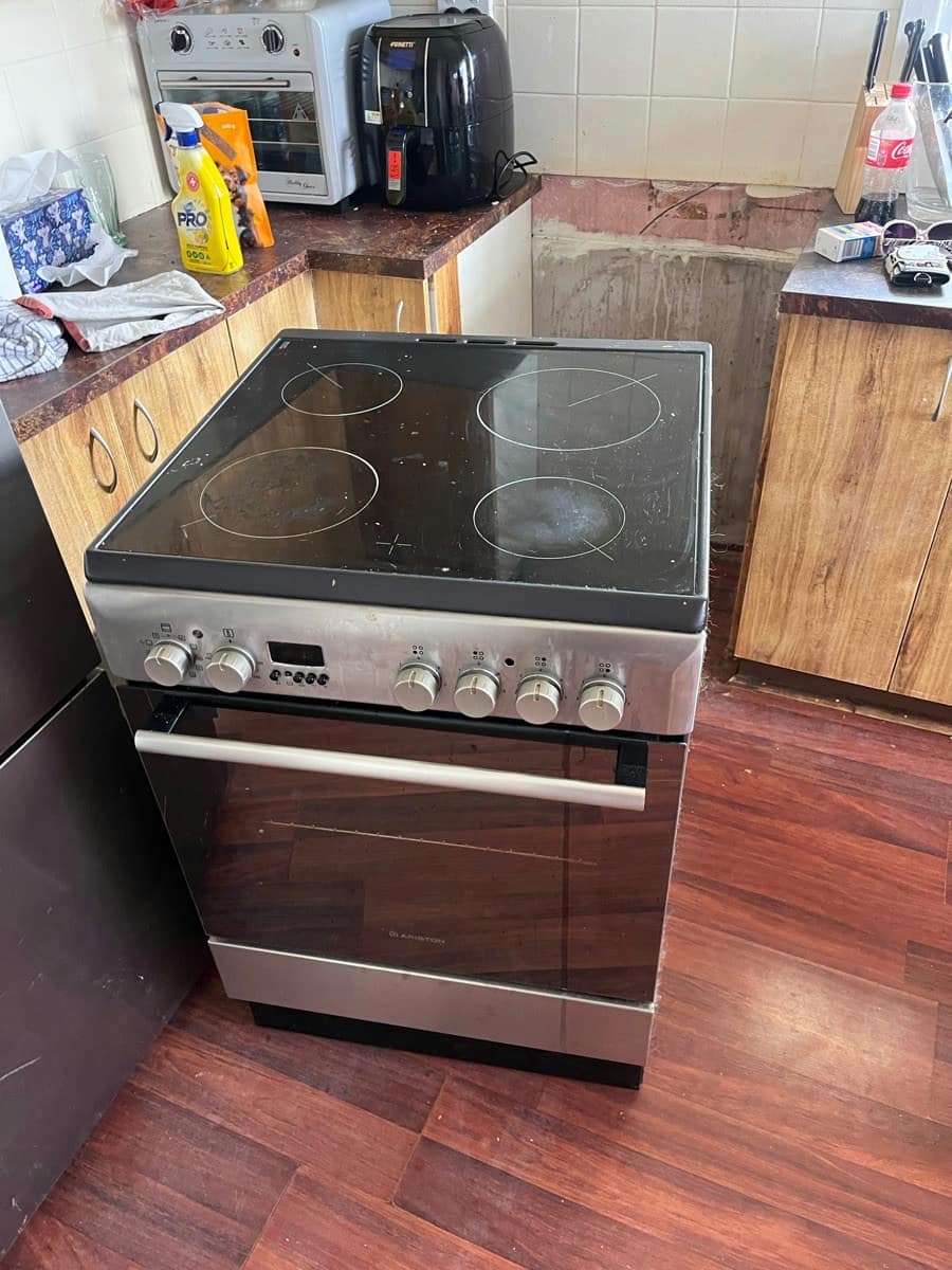 A new stainless freestanding stove installed between timber cabinets