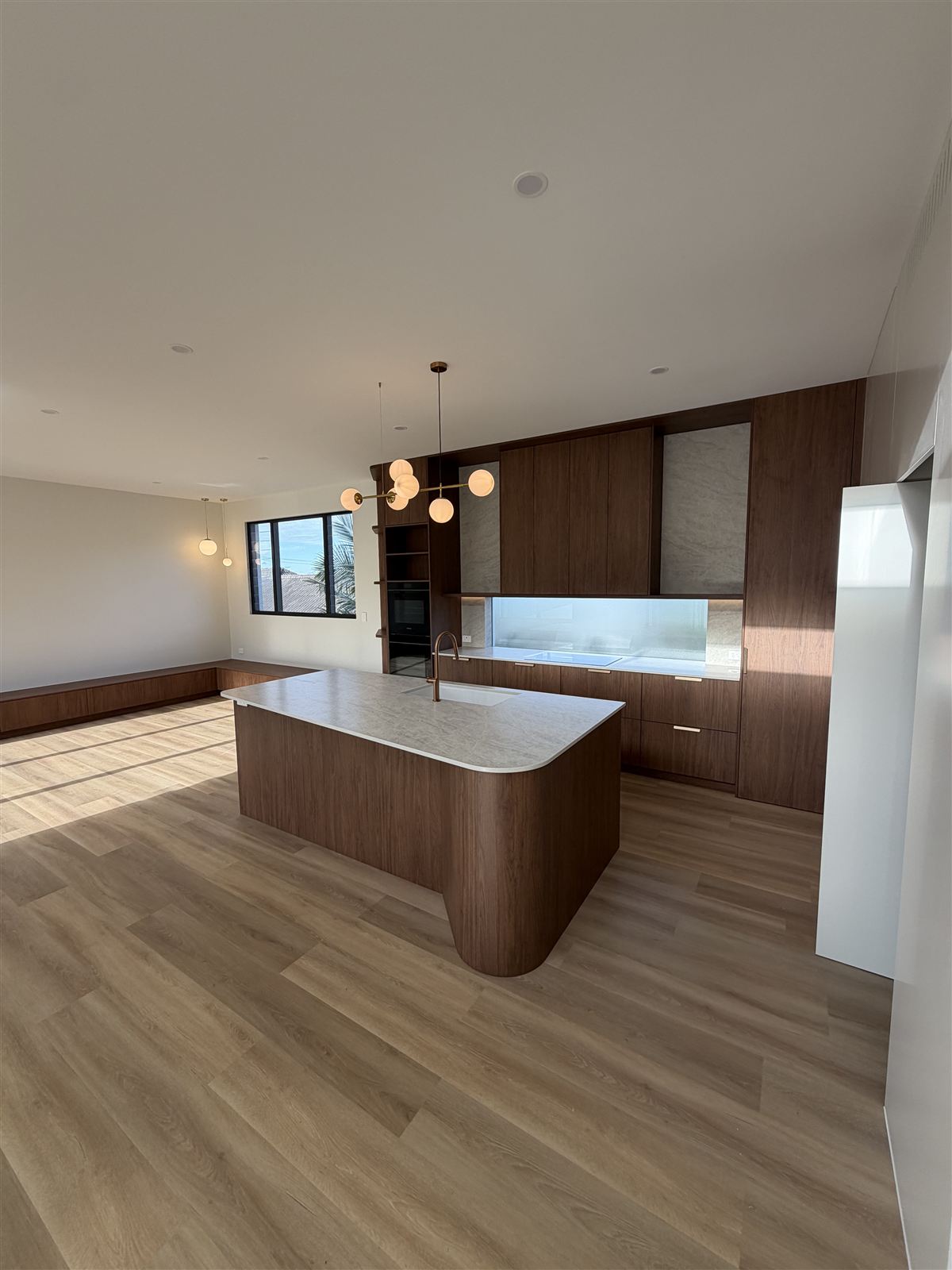 Finished kitchen with a built-in oven, cooktop and pendant lights