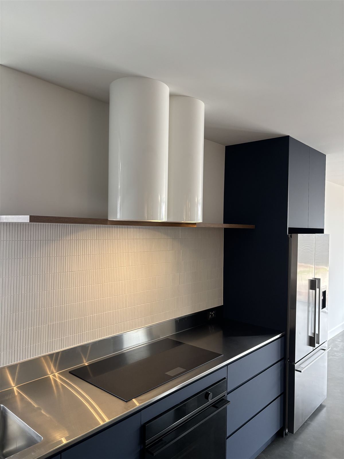 Induction cooktop and built-in oven in a finished kitchen