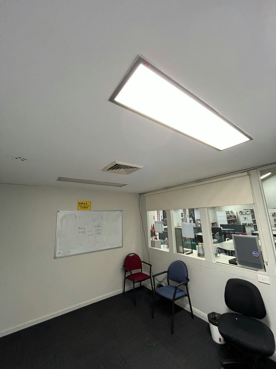 An LED ceiling panel lit above an empty meeting room