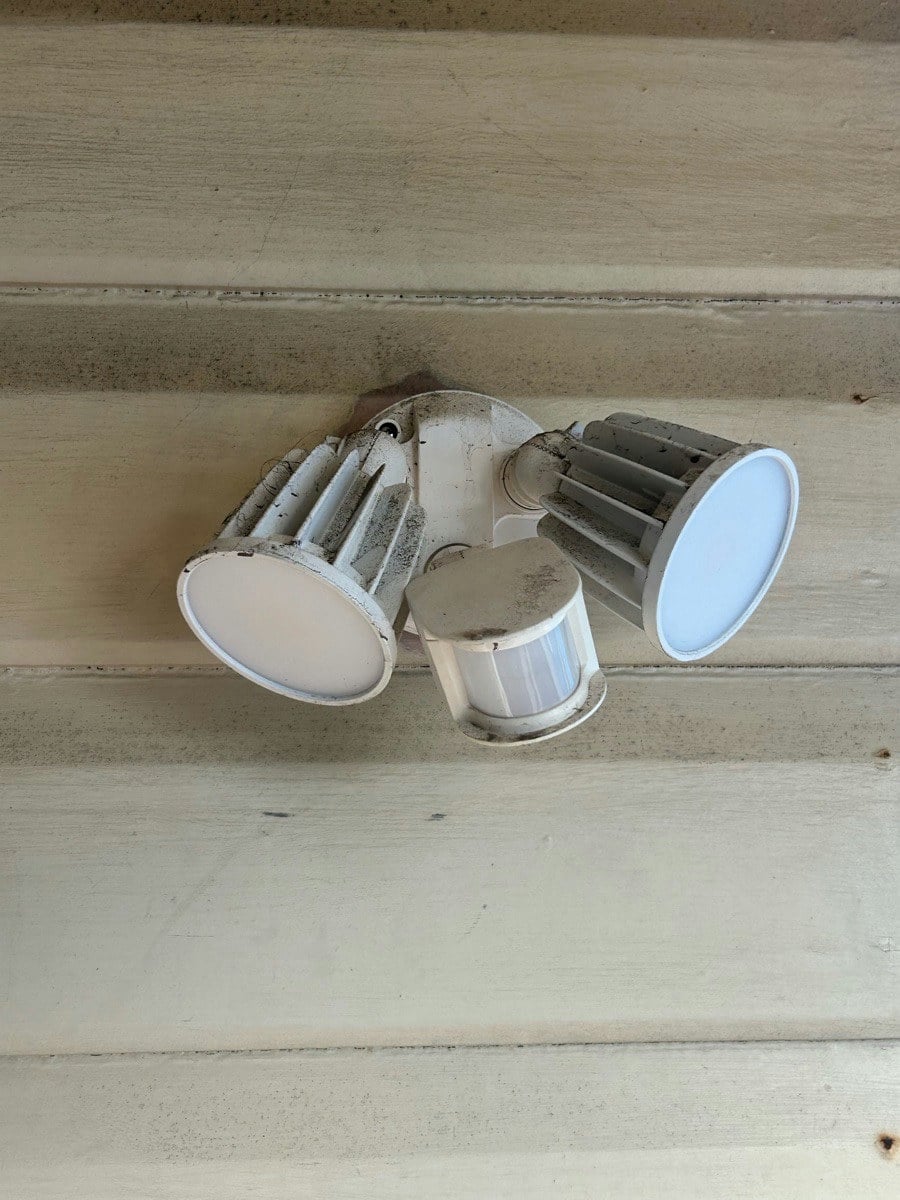A weathered twin-spot sensor light due for replacement