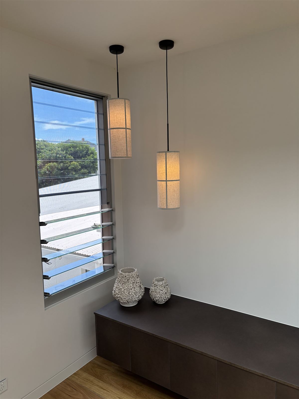 Pendant lights above a bench beside a window nook