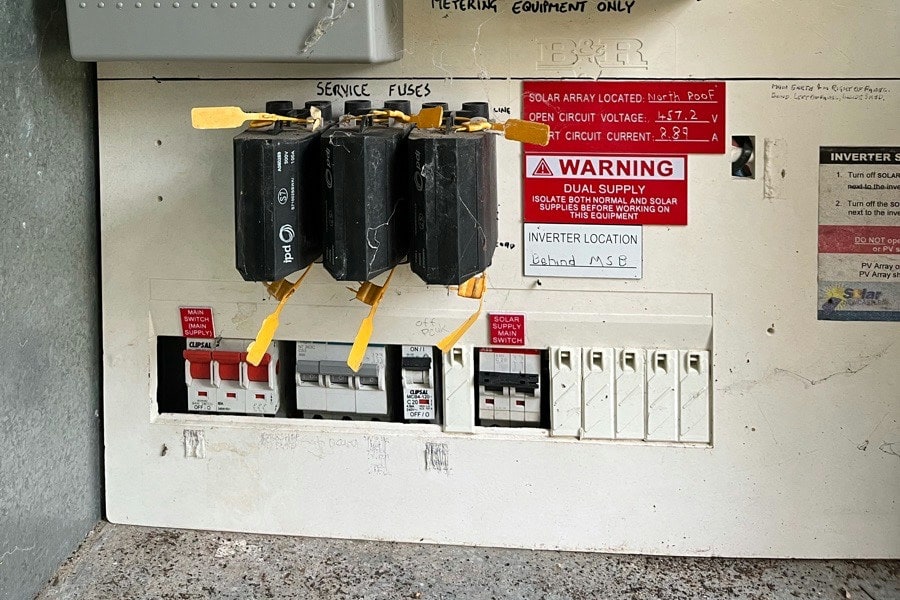 Service fuses above a main switch and a row of circuit breakers in a meter box