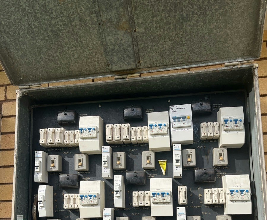 Rows of breakers, safety switches and fuse units filling a large shared switchboard