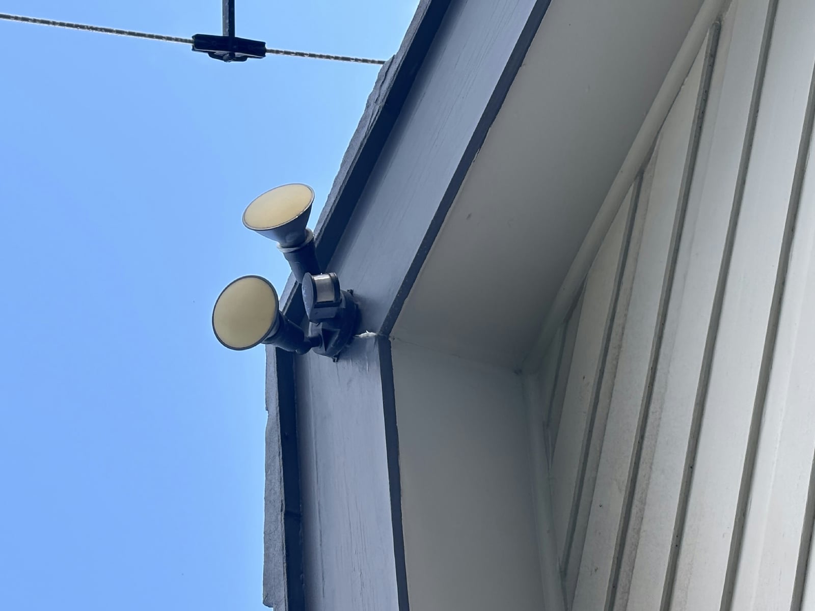 A twin-spot flood light mounted under an eave, out of the weather