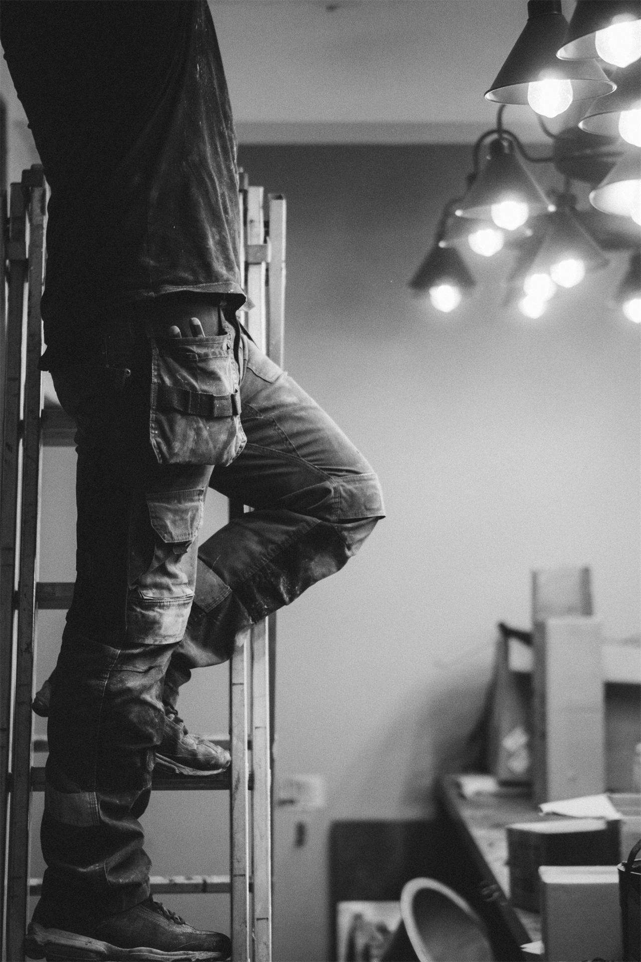 Electrician on a ladder working on a ceiling light