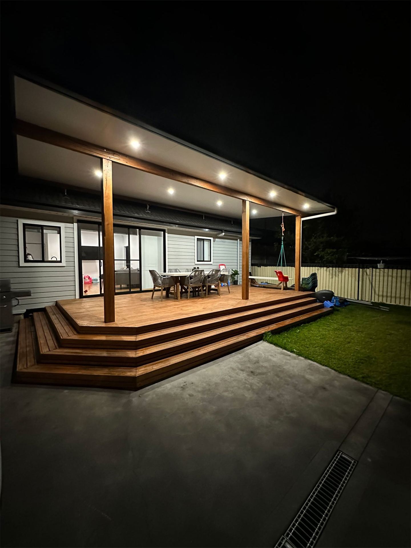 Outdoor deck lit at night by downlights installed by Barrack Electrical
