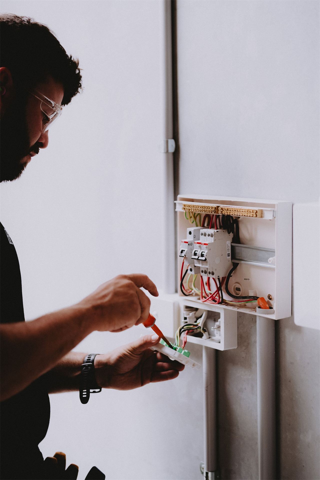 Electrician working inside a switchboard