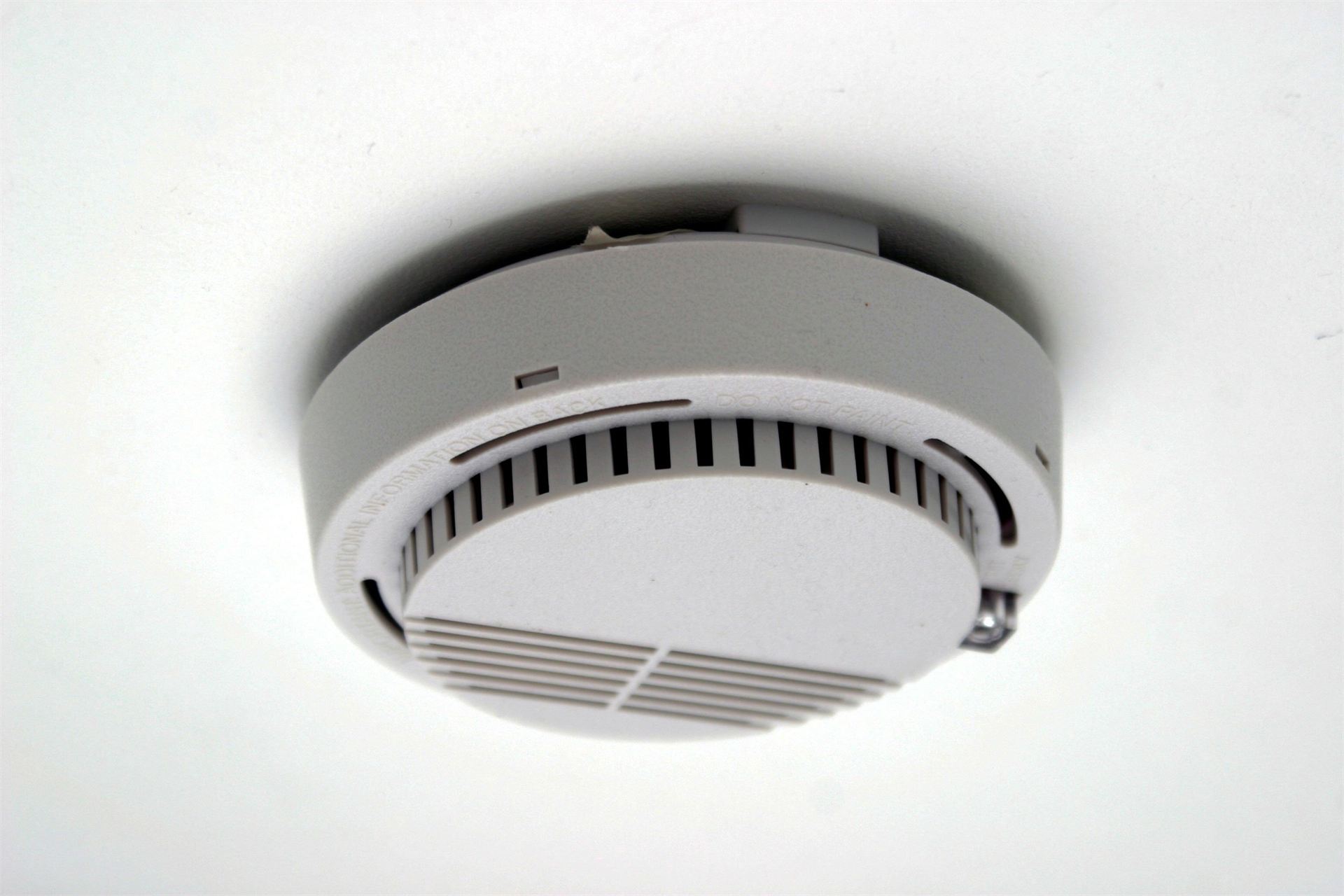Smoke alarm installed on a ceiling and tested