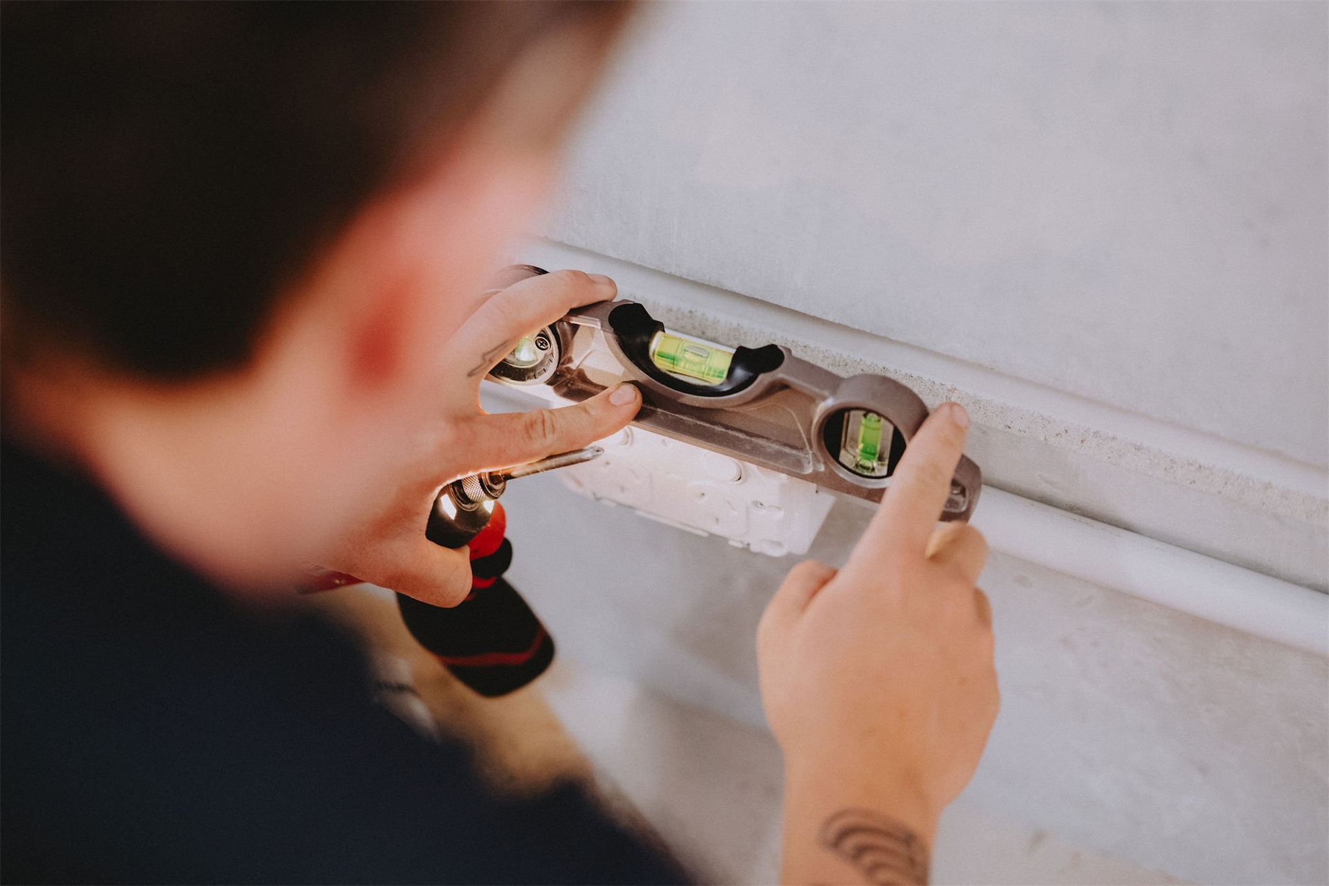 Electrician levelling a wall box for a power point
